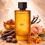 Perfume bottle labeled 'JEEZ' surrounded by vanilla beans, a rose, and gold elements on a warm background.