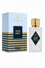 A bottle of Uppernote's Oud Mist perfume next to its packaging box. The bottle is made of textured clear glass with a shiny gold cap and a black and gold diamond-shaped label.